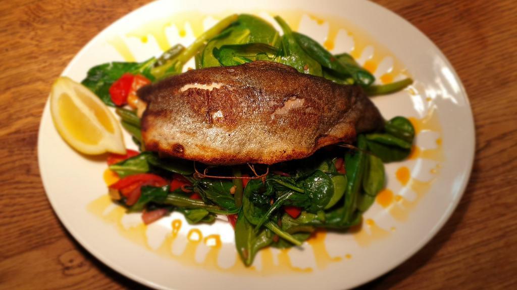 Rainbow Trout · Pan seared rainbow trout with spinach, cherry tomato, onion, garlic, and butter.