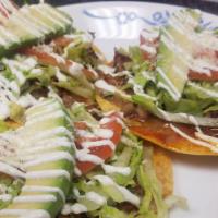 Tostadas · Three crispy flat corn tortillas topped with a spread of beans, meat of your choice, lettuce...