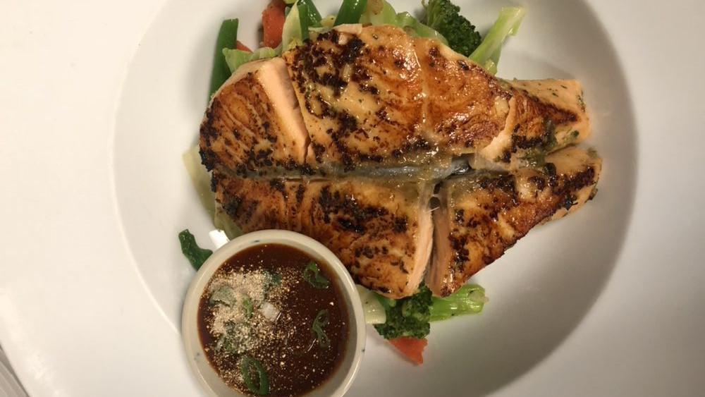 Grill Salmon · Marinated salmon served with a spicy Thai lemon dipping sauce in banana leaves.