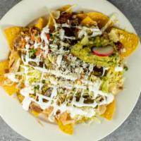 Nachos Grande · Topped with queso, shredded cheese, cotija cheese,  chicken, refried pinto beans, ground bee...