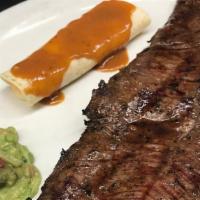 Steak Tampiquena · Skirt steak topped with sautéed onions, cheese enchilada, guacamole and rice and beans.