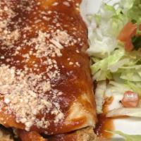 Enchiladas Texanas · Flour tortilla filled with grilled chicken and avocado and topped with red sauce and cheese.