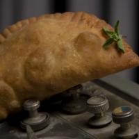 Chicken Empanada · Pulled Chicken, Roasted Tomatoes, Cheddar, Lime & Cilantro