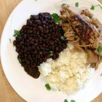 Pernil A La Don Pedro · Slow-roasted marinated pork served with rice and beans