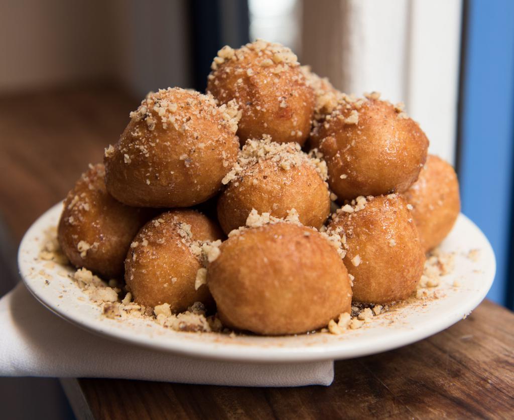 Loukoumades · Fried dough drizzled with honey, walnuts & cinnamon.