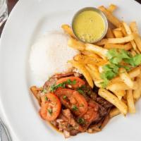 Lomo Saltado · sirloin steak, onions, tomato, garlic and ginger served with papa frita and rice.