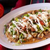 Huarache · Handmade thick tortilla. Topped with refried beans, lettuce, pico de gallo, sour cream and q...