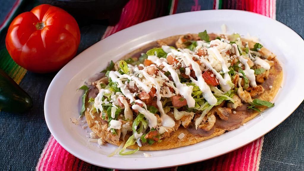 Huarache · Handmade thick tortilla. Topped with refried beans, lettuce, pico de gallo, sour cream and queso fresco.