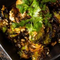 Charred Brussels Sprouts · with Cilantro Lime Vinaigrette and Puffed Rice.