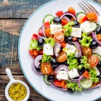 Greek Salad · Freshly prepared salad topped with Romaine lettuce, feta cheese, stuffed grape leaves, tomat...