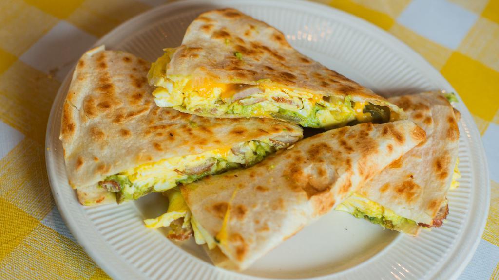 Wild West Breakfast · Quesadilla stuffed with eggs, jalapenos, sausage, and cheddar cheese. Comes with Guacamole and Home Fries yee haw!