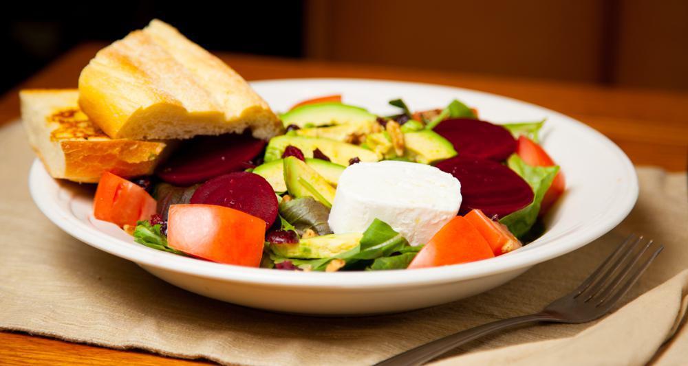 Goat Cheese Beet Salad · Arugula, cranberries, avocado, glazed walnuts, and red beets topped with goat cheese served on a garlic toasted French bread. Tossed in a balsamic vinaigrette.