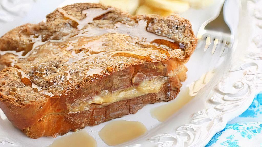 Banana Stuffed French Toast · Four slices of thick, egg-washed cinnamon bread stuffed with bananas and cream cheese, and topped with maple syrup.