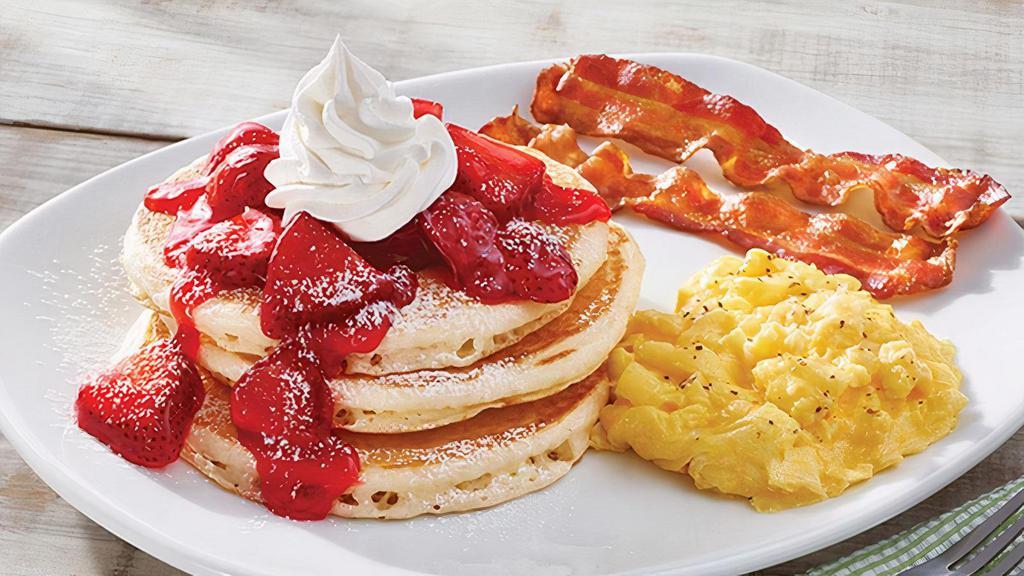 Fresh Strawberry Buttermilk Pancake Platter · Three of our famous buttermilk pancakes topped with fresh glazed strawberries, powdered sugar and whipped topping. Served with two eggs* and choice of two Applewood smoked bacon strips or two sausage links.
