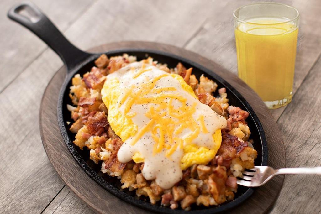 Big Country Sunrise Skillet · Pork sausage, Applewood smoked bacon, smoked ham, American cheese and cream gravy with two eggs served over crispy smashed tots. Served with orange juice or choice of beverage..