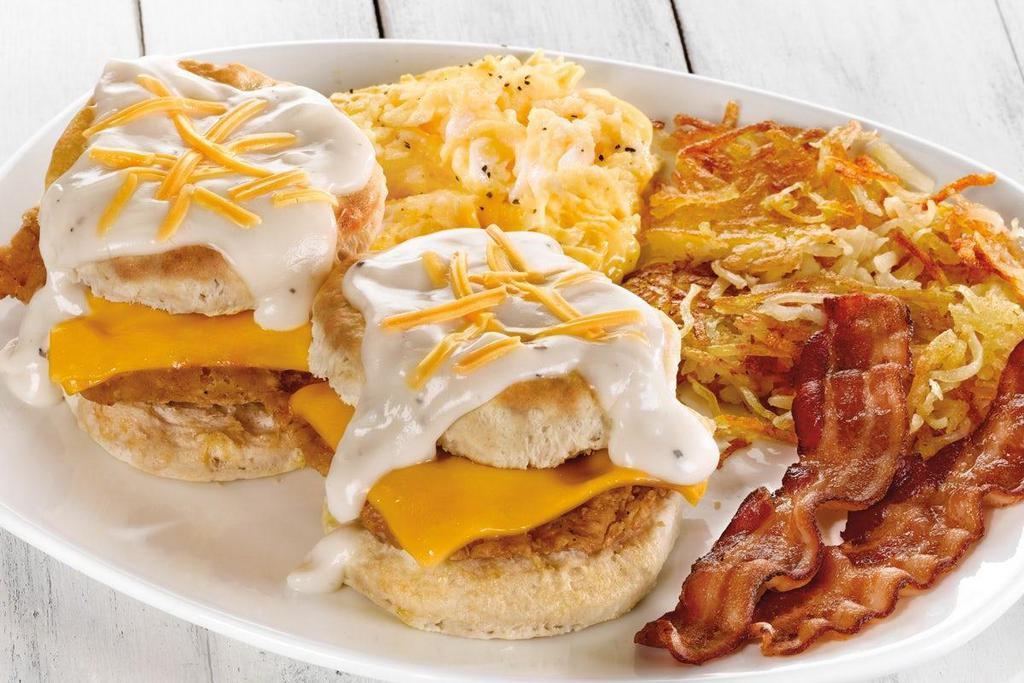 Southern Fried Chicken Biscuit Breakfast · A fried chicken fillet and Cheddar cheese inside two fresh baked biscuits.  Topped with American cheese and cream gravy, served with two eggs*, two Applewood smoked bacon strips and choice of hash browns or breakfast potatoes.