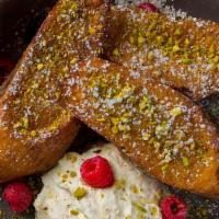 French Toast · On top: Pistachios, Powdered Sugar.
On the side: Raspberries, Rosewater Whipped Cream, Maple...