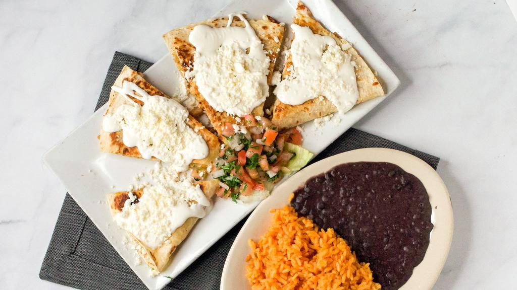 Quesadillas · Choice of Tortilla Stuffed with Melted Cheese, Garnished with Crema, Queso Fresco and pico de Gallo, rice and beans or salad