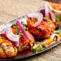 Murgh Tandoor · Skewered chicken on the bone and red marinade.