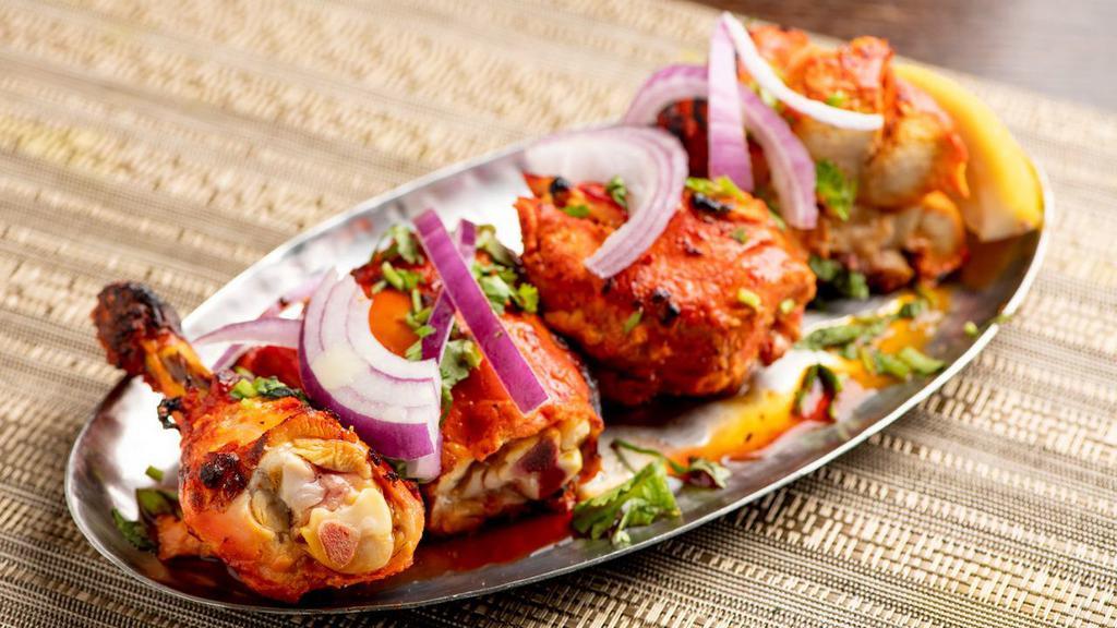 Murgh Tandoor · Skewered chicken on the bone and red marinade.