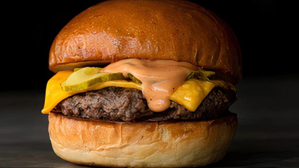 Award Winng Cheeseburger · Fresh ground beef seared with caramelized onions, topped with American cheese, pickles, and secret sauce on toasted Brioche Bun.