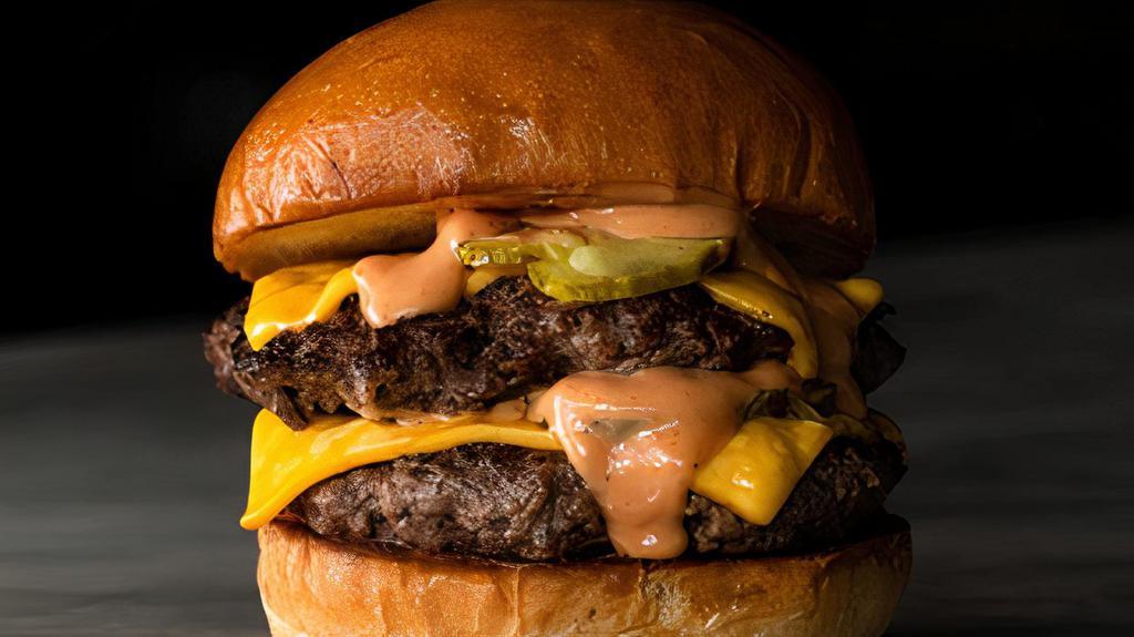 Double Cheeseburger · Two perfectly grilled patties, caramelized onions, pickles, 2 slices American cheese, burger sauce on a toasted brioche bun.