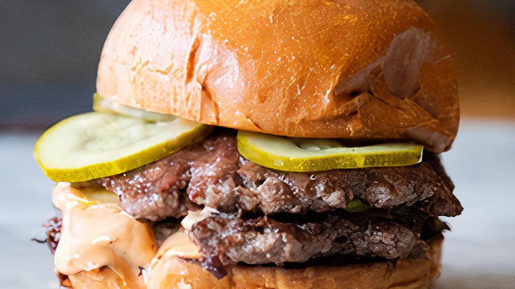 Double Burger · Two perfectly grilled patties, caramelized onions, pickles, burger sauce on a toasted brioche bun.