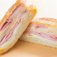 Toasted Monte Cristo Panini · Delicious Layers of ham, smoked turkey, swiss and cheddar cheese, lettuce, tomatoes, and hon...