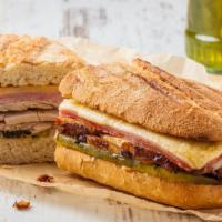 Cuban Panini · Juicy roasted pork, ham, swiss cheese, pickles, and mustard on european flatbread.