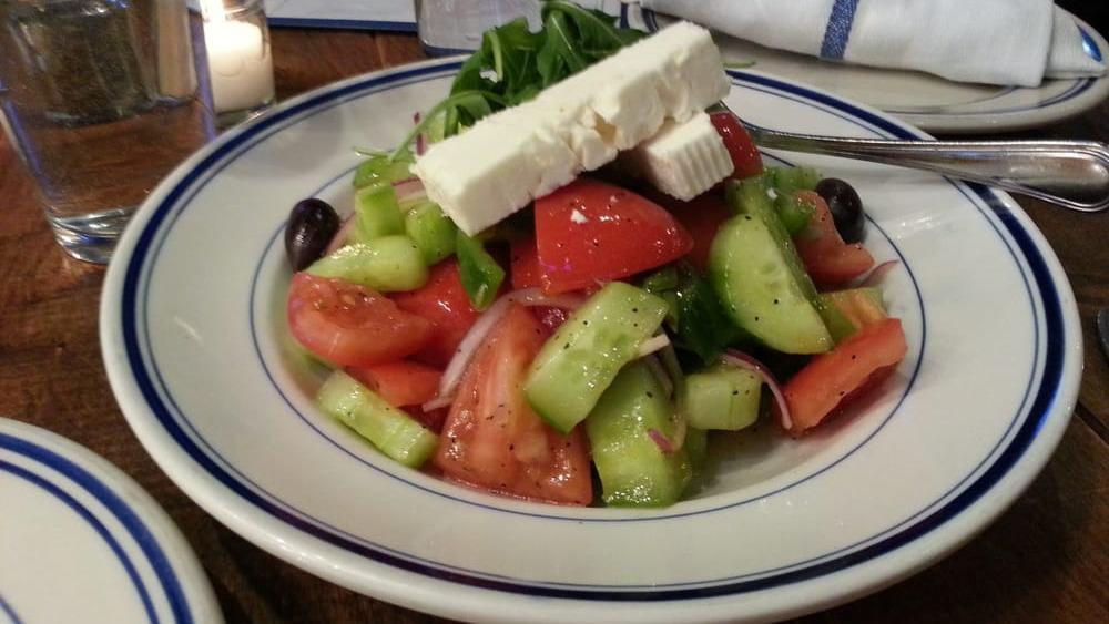 Horyatiki Salad · Tomato, cucumber, feta, olives, green peppers, and red onions served with an extra virgin olive oil vinaigrette.