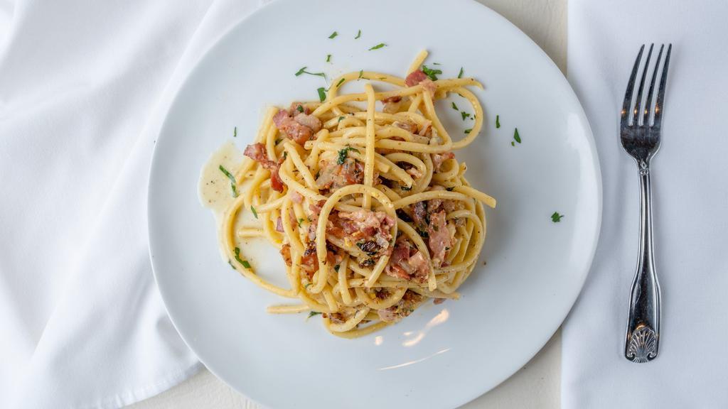 Bucatini Carbonara · Thick spaghetti, bacon, onion, egg yolk, grated parmigiano, and olive oil.