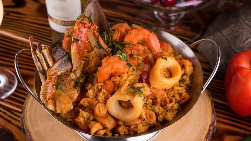Arroz Con Mariscos · Traditional Peruvian paella with aji Amarillo seafood rice; accompanied with calamari, mussels, shrimps, and crabs. Topped with cilantro.