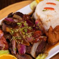 Bistek Encebollado · Tender steak marinated in a flavor-packed combination of onions and garlic sauce. Accompanie...