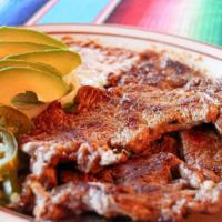 Carne Asada · Grilled steak and thinly cut. served with Mexican rice, refried beans, lettuce, guacamole, a...