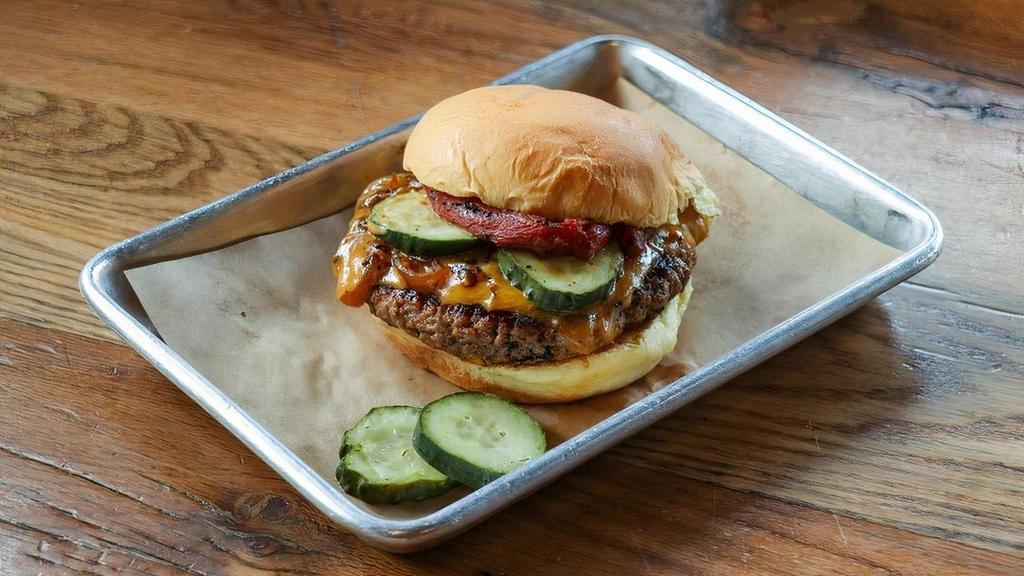 Impossible Burger · Plant Based Burger, Caramelized BBQ Onions, melted cheddar, smoked plum tomatoes, pickle, zip sauce
