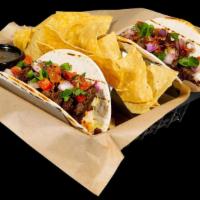 Carne Asada Tacos · Lime-basted chopped steak, house slaw, pico de gallo and cilantro. Served with chips and sal...