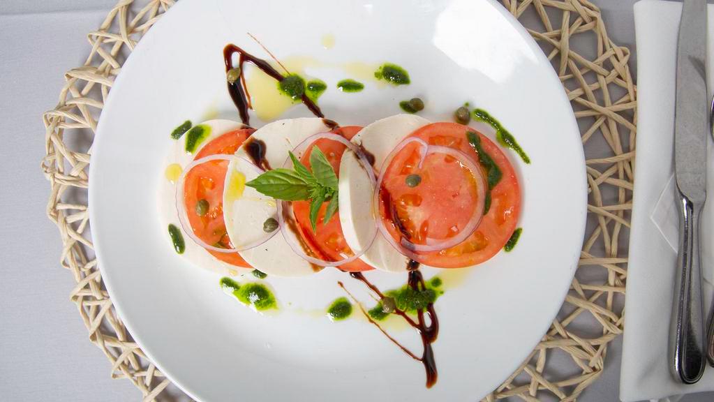Caprese · Beefsteak tomato, fresh mozzarella, pickled red onion, capers and fresh basil drizzled with balsamic glaze and extra-virgin olive oil.