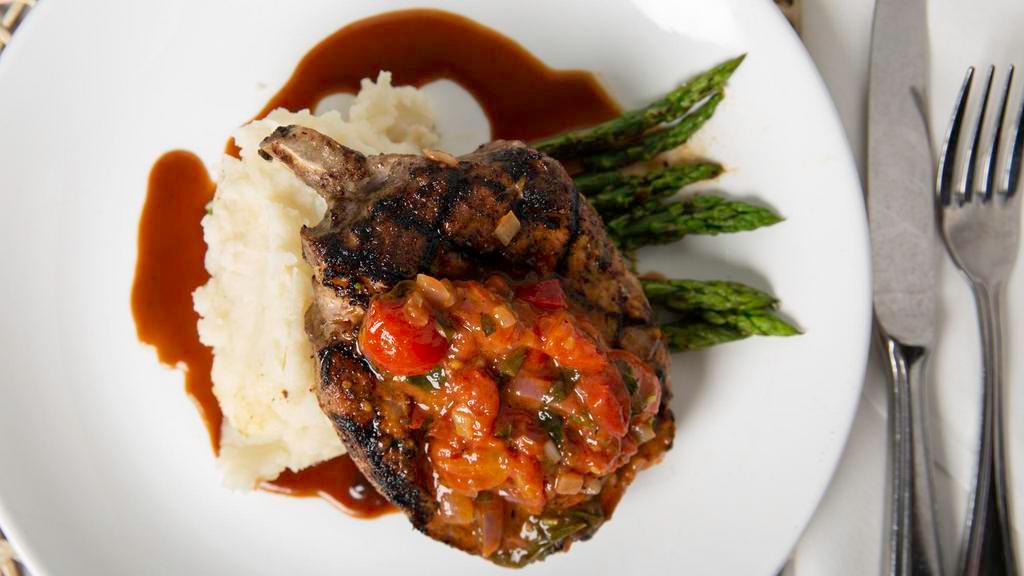 Reserve Center Cut Pork Chop · Double cut, bone-in grilled pork chop, agro-dolce peppers &  onions, served over roasted garlic mashed potatoes, topped with a sweet and sour balsamic glaze
