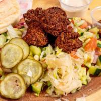Whole Falafel · Whole pita filled with freshly made falafel balls, sauerkraut, Israeli salad, pickles, & Teh...