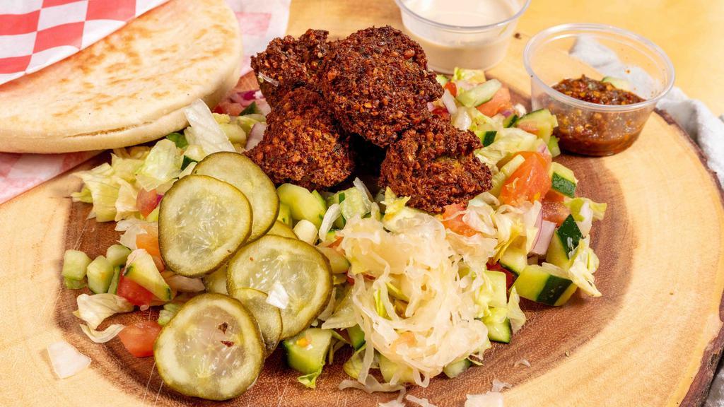 Whole Falafel · Whole pita filled with freshly made falafel balls, sauerkraut, Israeli salad, pickles, & Tehina