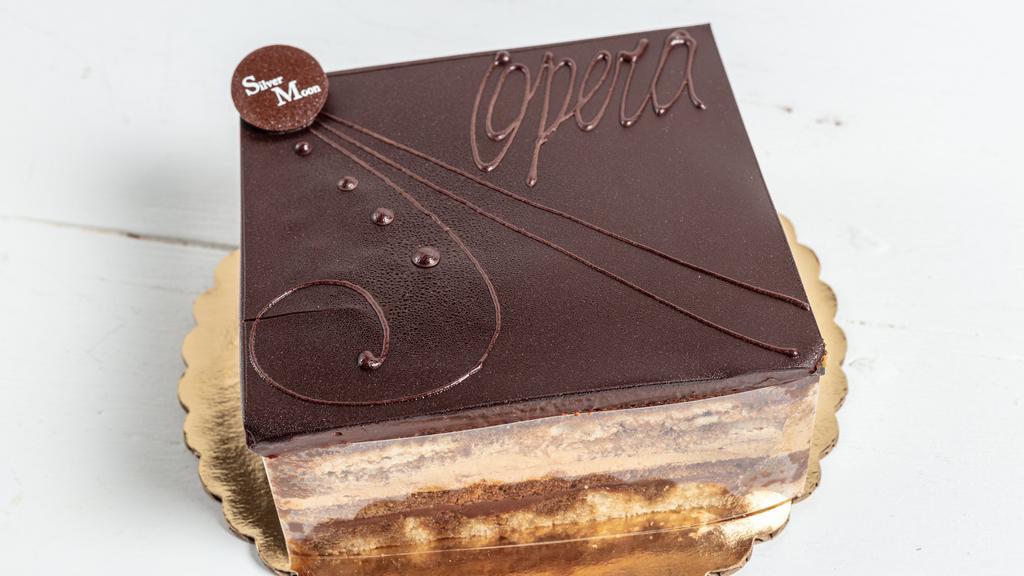 Opera Cake · A truly delicious cake, inspired by the  Paris Opera House! It includes a total of six layers made of almond dacquoise, vanilla sponge, mocha buttercream, vanilla buttercream, and dark chocolate ganache, topped with a chocolate glaze. 6