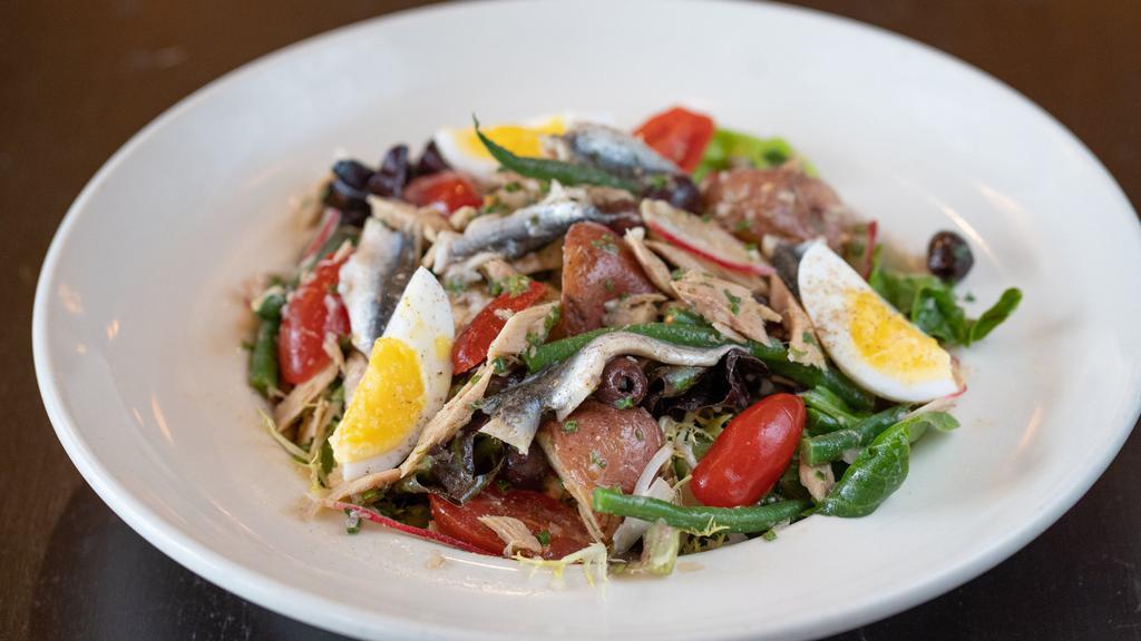 Salade Niçoise · Spanish tuna, gem lettuce, frisee and bibb lettuces, haricots verts, confit potatoes, cherry tomatoes, nicoise olives, and hard-boiled egg with white anchovy vinaigrette