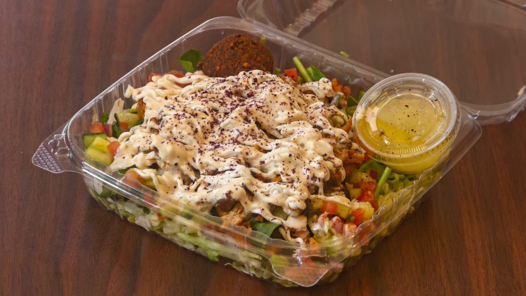 Chicken Shawarma Salad · Flavorful, fresh greens that include: baby spinach, Romaine lettuce, tossed with our famous house salad (cucumber, tomatoes, onions), then topped with chicken shawarma, covered with garlic sauce, olive oil, white vinegar, and shredded garlic.  Each bite is crisp, bright, and bursting with flavor.
