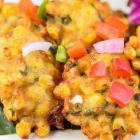 Sweet Corn Fritters · Sweet corn kernels with cilantro topped with a cucumber sauce.