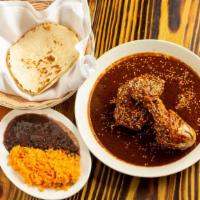 Mole Poblano · Seared chicken, sautéed with mole sauce, served with rice and beans and tortillas.