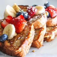 Multigrain French Toast · garnished with fresh berries, bananas, cinnamon & powdered sugar. served with sugar free syr...