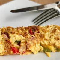 Tortilla Con Ajíes Y Cebolla · Pepper and onion omelette.