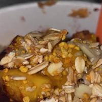 Mango Tango Bowl · Acai bowl topped with  granola, strawberries, mango, almond slices, and honey.