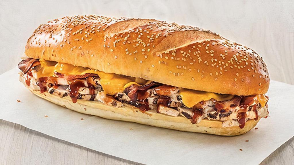The Cowboy · Grilled chicken and crispy bacon smothered in BBQ sauce with melted cheddar cheese on a fresh-baked sesame roll. Customize it to make it your own!
