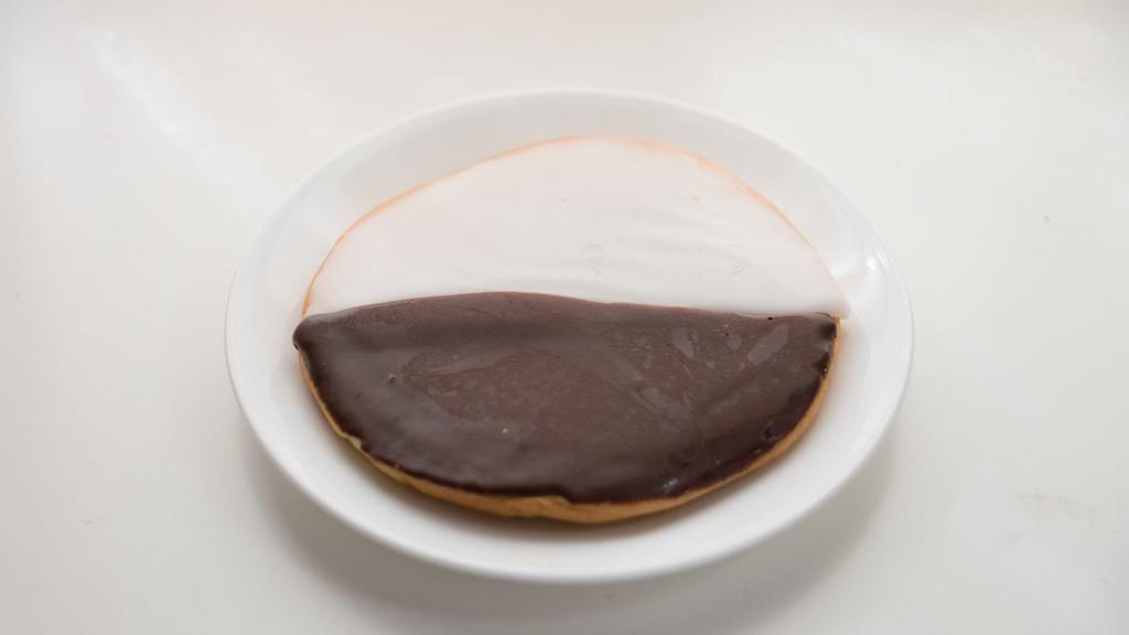 Black And White Cookie · Soft, cakey cookies covered in a thick layer of icing flavored with both vanilla and chocolate.